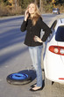 Photo: Young woman standing by her damaged car and calling for help Young woman standing by her damaged car and calling for help