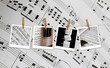 Polaroid musicali appese a mollette su partitura musicale