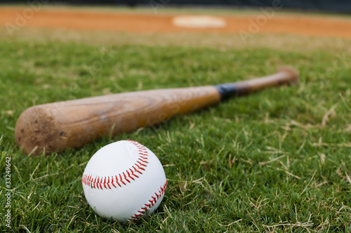 Photo: Baseball and Bat on Field Baseball and Bat on Field