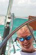 Middle-aged man steering sailboat
