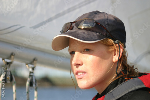 Photo: Young woman dinghy sailing at regatta Young woman dinghy sailing at regatta