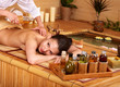 Woman getting massage in bamboo spa.