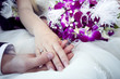 Hands and rings on wedding bouquet