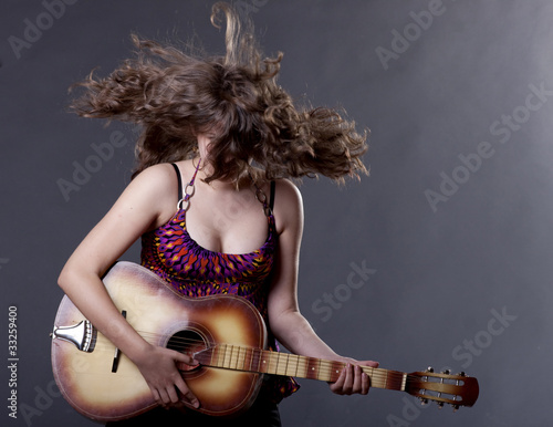 Photo: Young woman playing guitar Young woman playing guitar