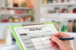 Hand Writing a Diet Plan in front of an open Fridge