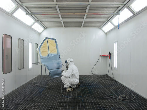 Photo: painter works in a spray booth painter works in a spray booth