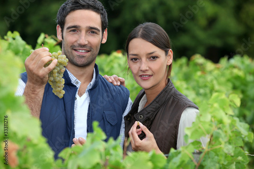 Photo: young couple proud of their vineyard young couple proud of their vineyard