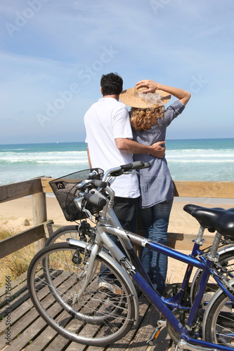 Photo: Couple with bikes by the sea Couple with bikes by the sea