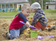 Boy and girl play in the sandpit in the playground