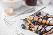 Freshly prepared crepes with blueberries & chocolate sauce