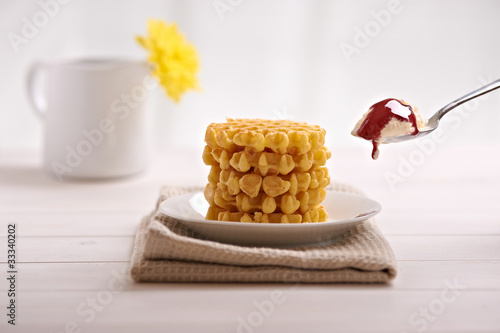 Photo: belgian waffles and ice cream in the dish on a white table belgian waffles and ice cream in the dish on a white table