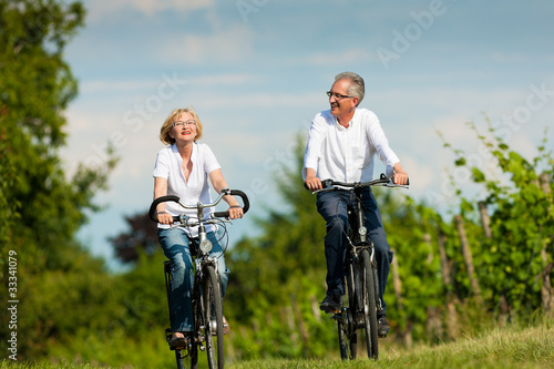 Foto: Glückliches Paar fährt Rad in der Natur im Sommer Glückliches Paar fährt Rad in der Natur im Sommer