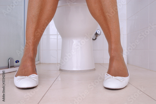 Photo: Frau sitzt auf einerToilette Frau sitzt auf einerToilette