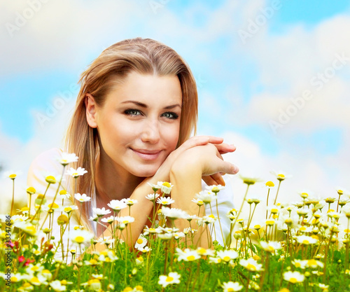 Photo: Beautiful female laying on the flower field Beautiful female laying on the flower field