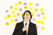 young businessman with postit reminder notes on the background young businessman with postit reminder notes on the background