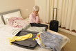 Ältere Frau packt Reisekoffer