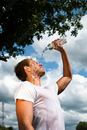 Foto: sportsman refreshing himself with a bottle of water sportsman refreshing himself with a bottle of water