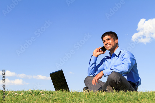 Foto: businessman with cell phone and laptop at the park businessman with cell phone and laptop at the park