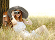 Redhead girl sitting near tree with vintage camera.