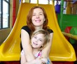 daughter and mother together in playground slide