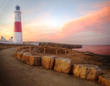 Victorian lighthouse on promontory of rocky cliffs during stunni