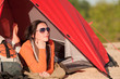 Camping happy woman in tent on beach sunset