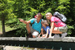 Family sitting on bridge over mountain river