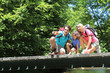 Family sitting on bridge over mountain river