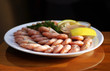 Shrimp cocktail on plate with sauce, lemon slices, and parsley