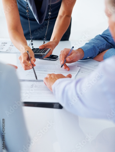Foto: Business people calculating budget together Business people calculating budget together