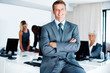 Smiling business man with colleagues in background