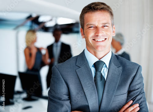 Photo: Male executive with colleagues Male executive with colleagues