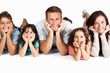 Portrait of cheerful family lying with hands on chin in row