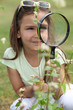 Girl looking through magnifying glass