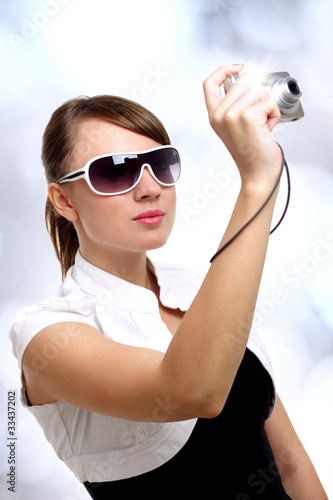 Photo: Young stylish woman with a camera Young stylish woman with a camera