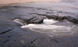 Wave retracting over rocks with blurred motion patterns