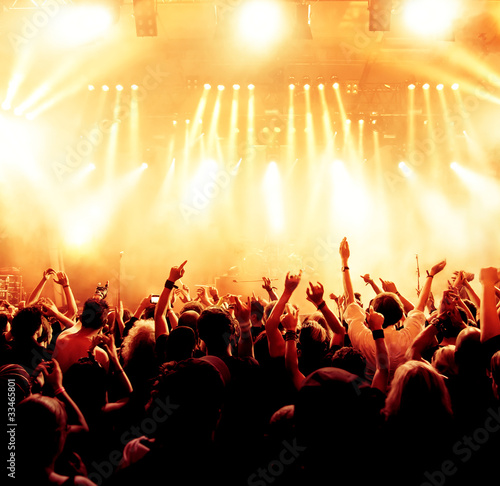 concert crowd in front of bright yellow stage lights