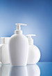 white skin care bottles on blue background