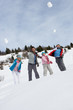 Young Family Throwing Snowballs On Winter Vacation