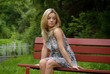 Woman sitting on a red bench in the garden
