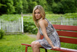 Woman sitting on a red bench in the garden