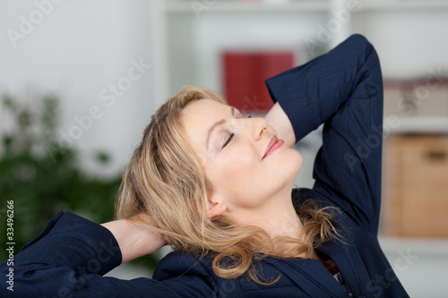 Foto: blonde frau streckt sich am schreibtisch blonde frau streckt sich am schreibtisch