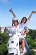 Portrait of happy young love couple on scooter enjoying summer t