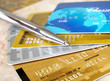 Silver pen on the pile of credit cards .