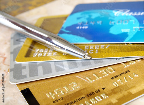 Photo: Silver pen on the pile of credit cards . Silver pen on the pile of credit cards .