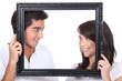 Young couple behind photo frame
