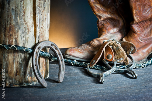 Photo: Cowboy boots,horseshoe,whip and spurs on wood Cowboy boots,horseshoe,whip and spurs on wood