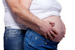 Photo: Man and woman's hands over pregnant belly on white Man and woman's hands over pregnant belly on white