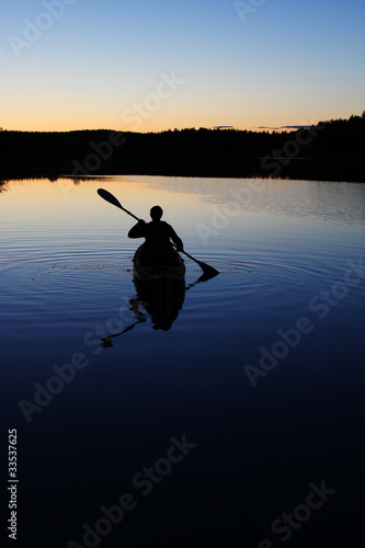 Photo: Sillouette of man kayaking on lake Sillouette of man kayaking on lake