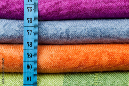 Foto: Stack of colorful cotton cloth with a measuring tape across Stack of colorful cotton cloth with a measuring tape across